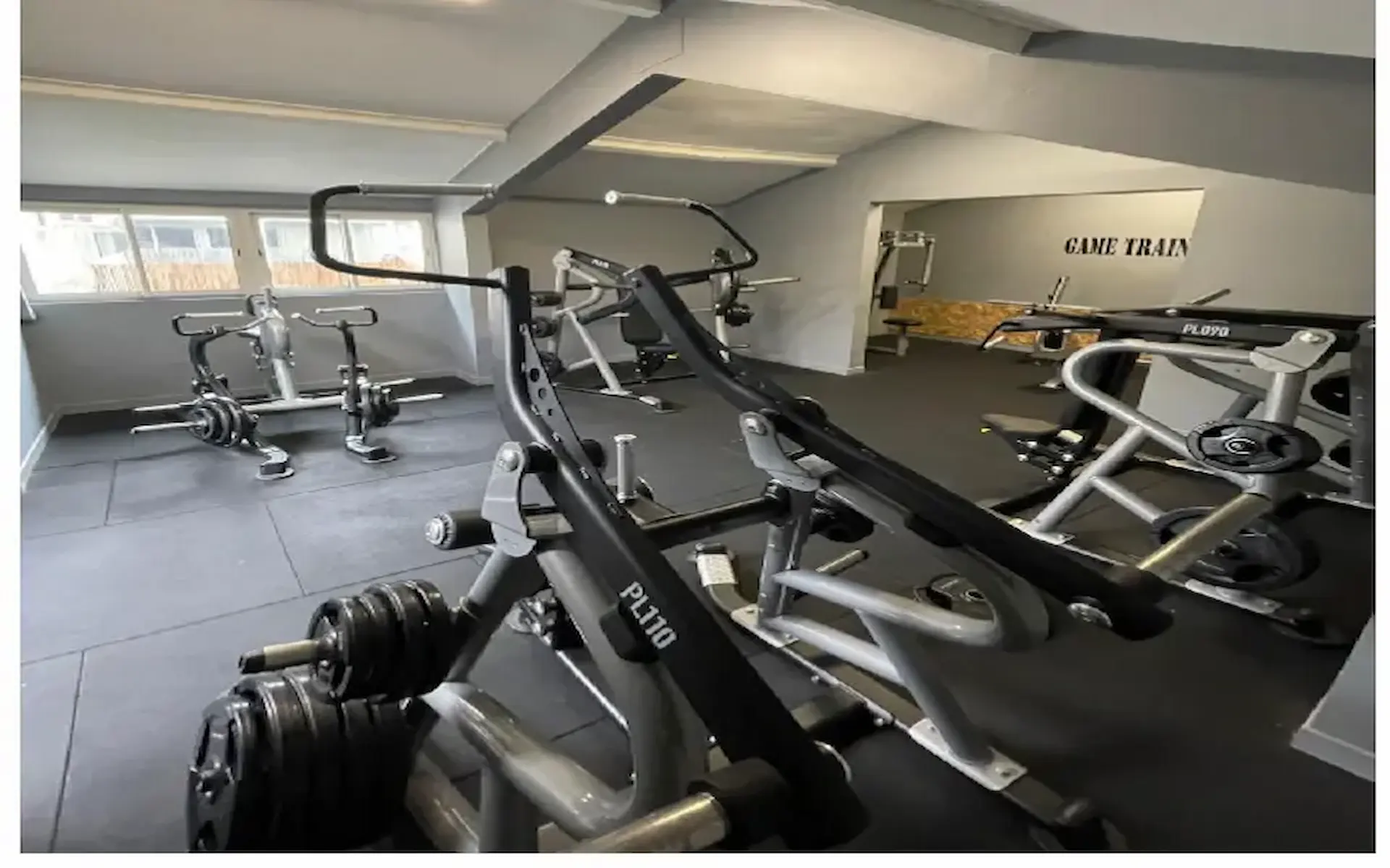 Coach sportif en séance de musculation dans une salle de sport